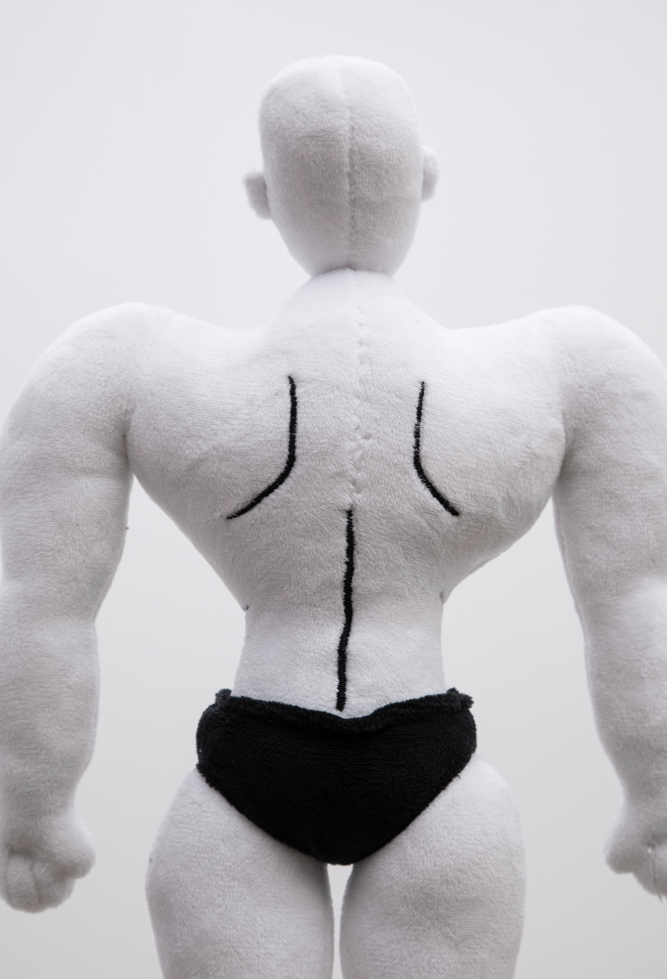 Close up back detail of a Plush muscular male character with white skin and black briefs.
